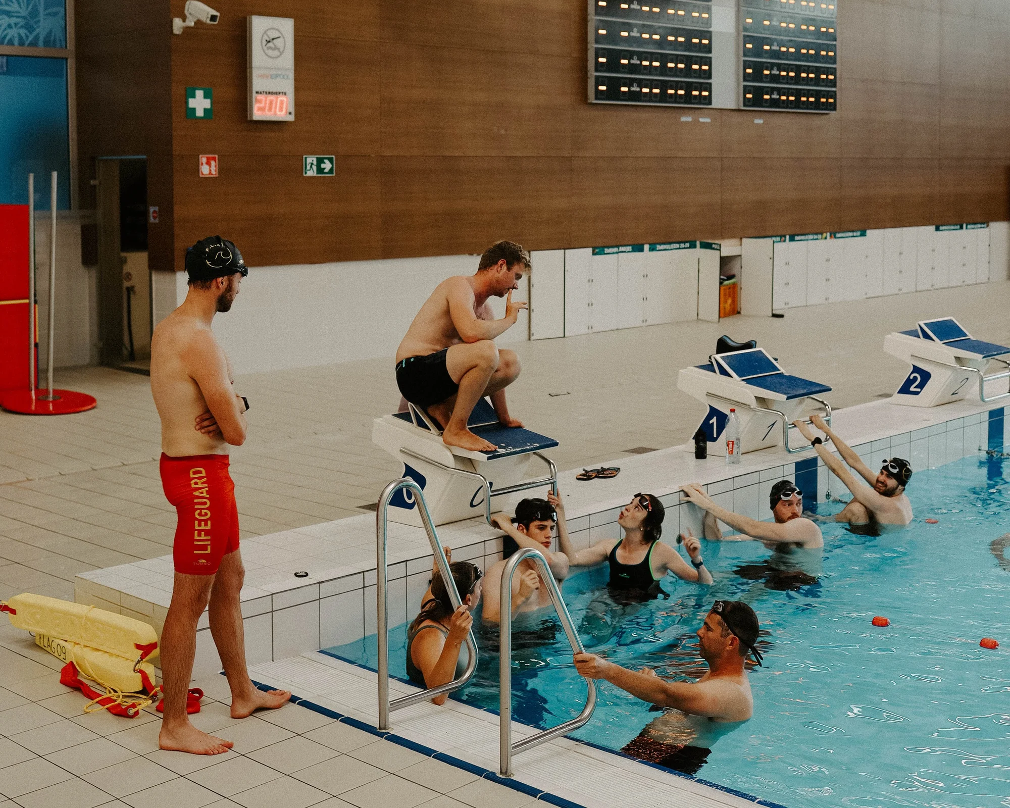 Lifesaving-training in het zwembad met een trainer op de badrand
