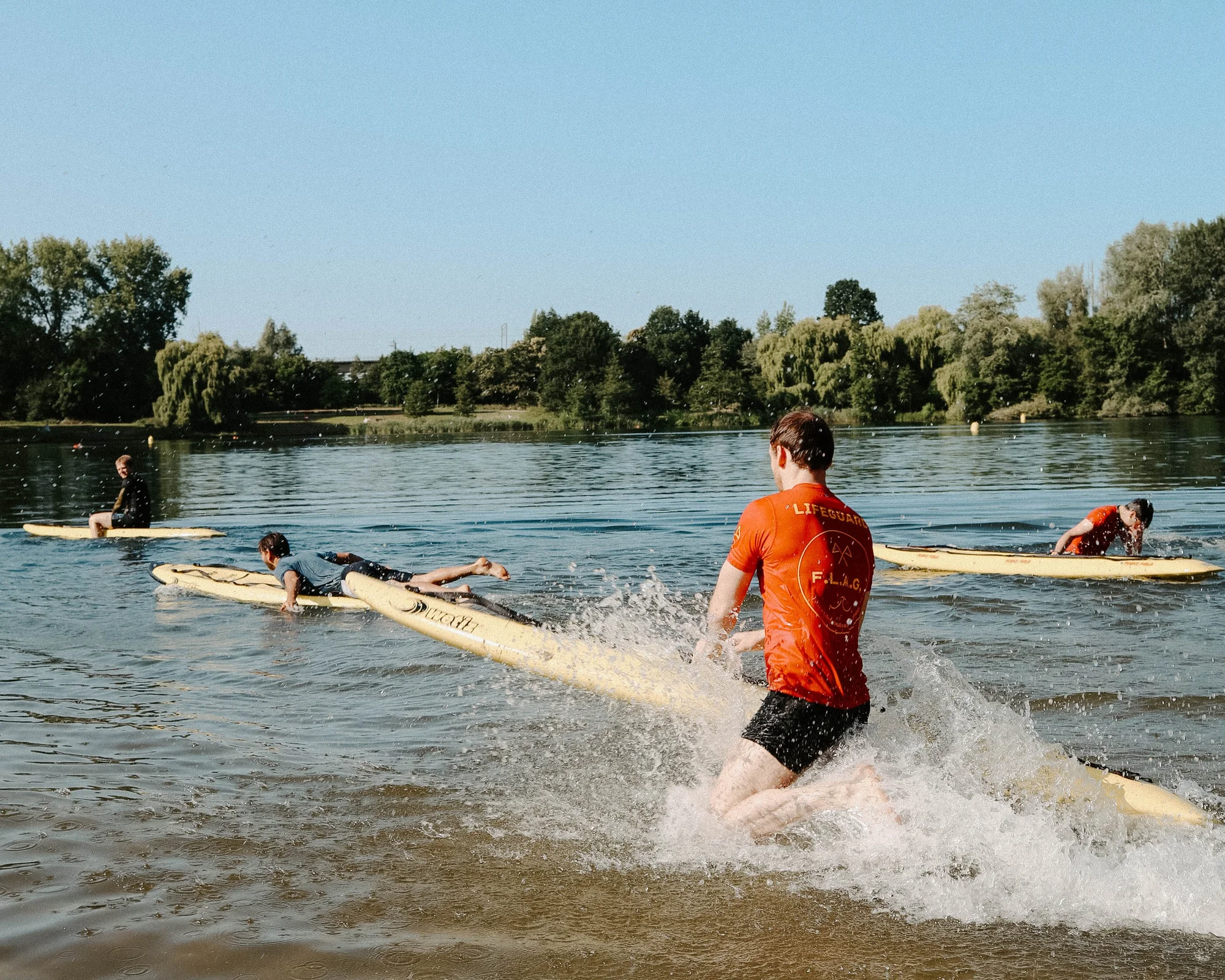 Een lid van FLAG loopt met een rescue board het water in